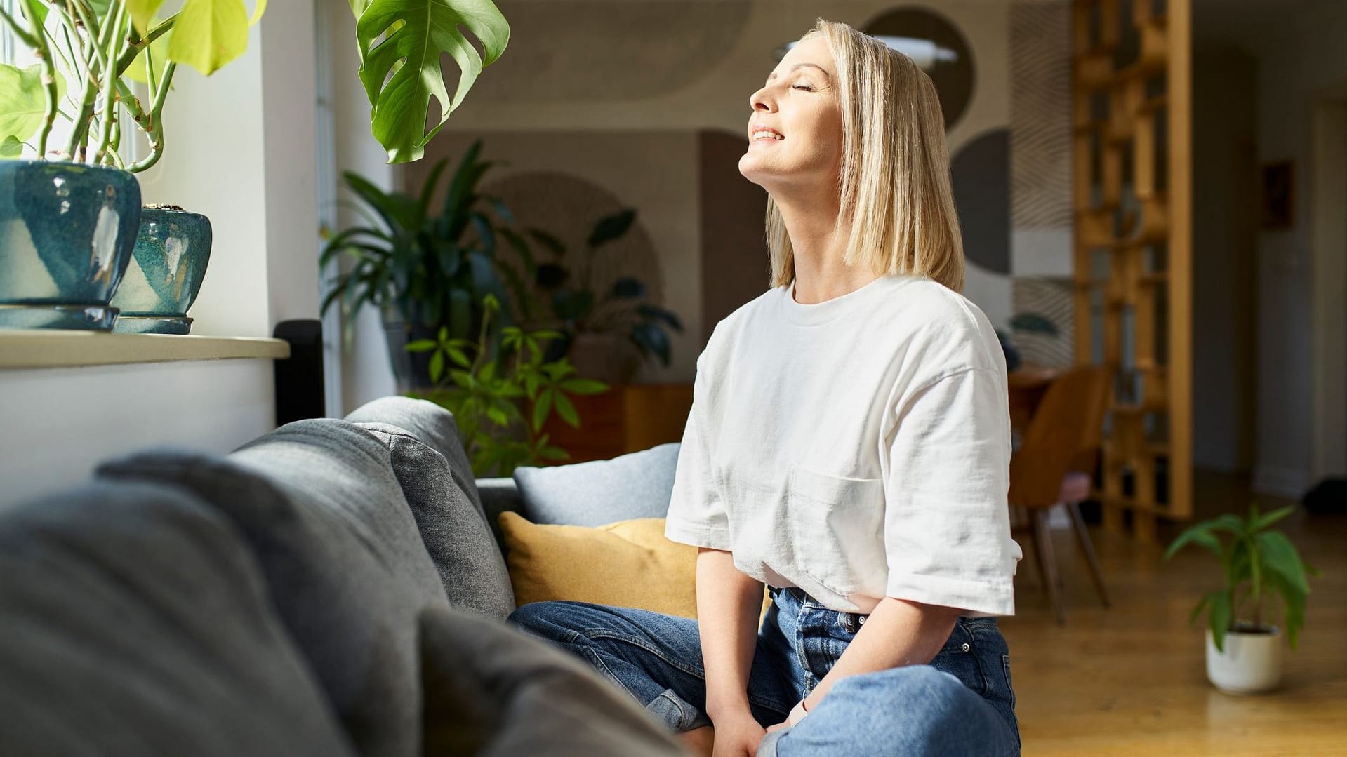 Woman sitting on couch trying to be positive and fight off Existential Dread